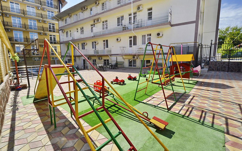 Детская игровая площадка с горкой, качелями и другими игровыми атрибутами в отеле Ziridis